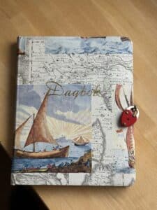 Dagbok med segelbåt och rött hänglås.