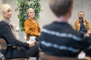 rupp av chefer i diskussion om hur man kan motivera medarbetare genom att skapa förutsättningar för inre motivation, vilket leder till högre engagemang och prestation.