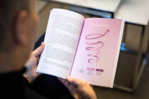 Person håller boken Reflektionens kraft öppen på uppslaget om Reflektionsspiralen — Ylva M Andersson
